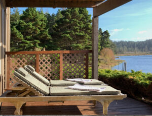Lower porch with loungers at the Floras Lake Getaway